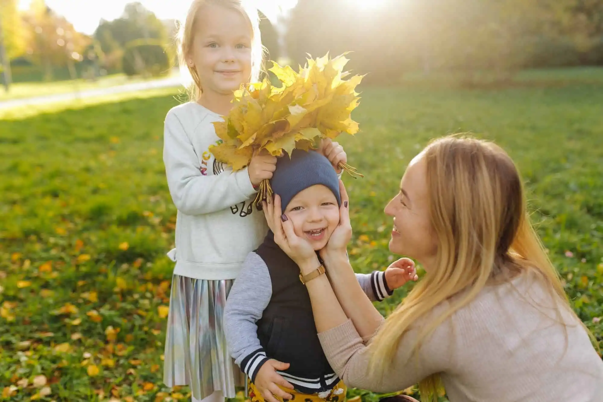 Mother and children playing in the park in autumn